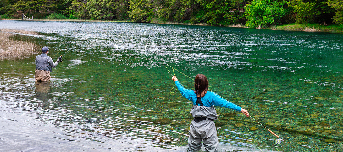 photo: a fly fisher casts into a river