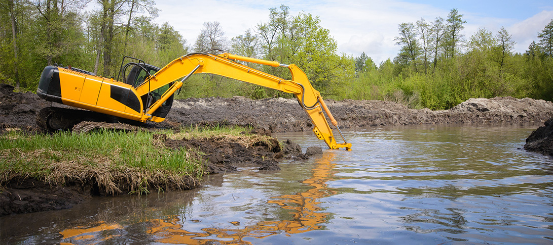 photo: an excavator addresses pond sedimentation