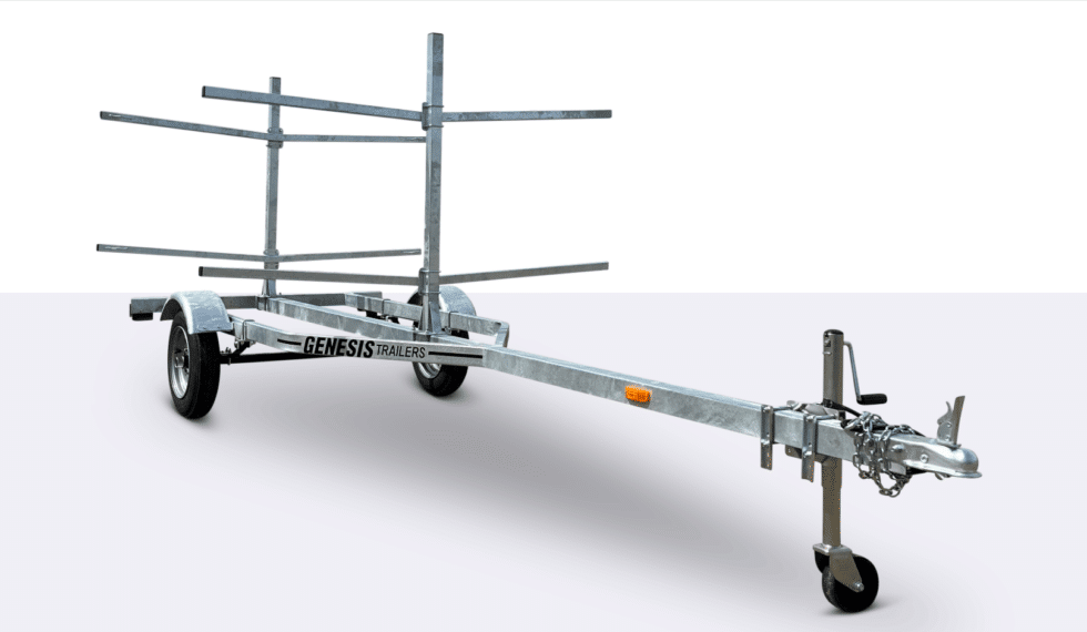 A metal Genesis trailer with racks for transporting kayaks or canoes, featuring two wheels, a long frame, and a hitch for towing.